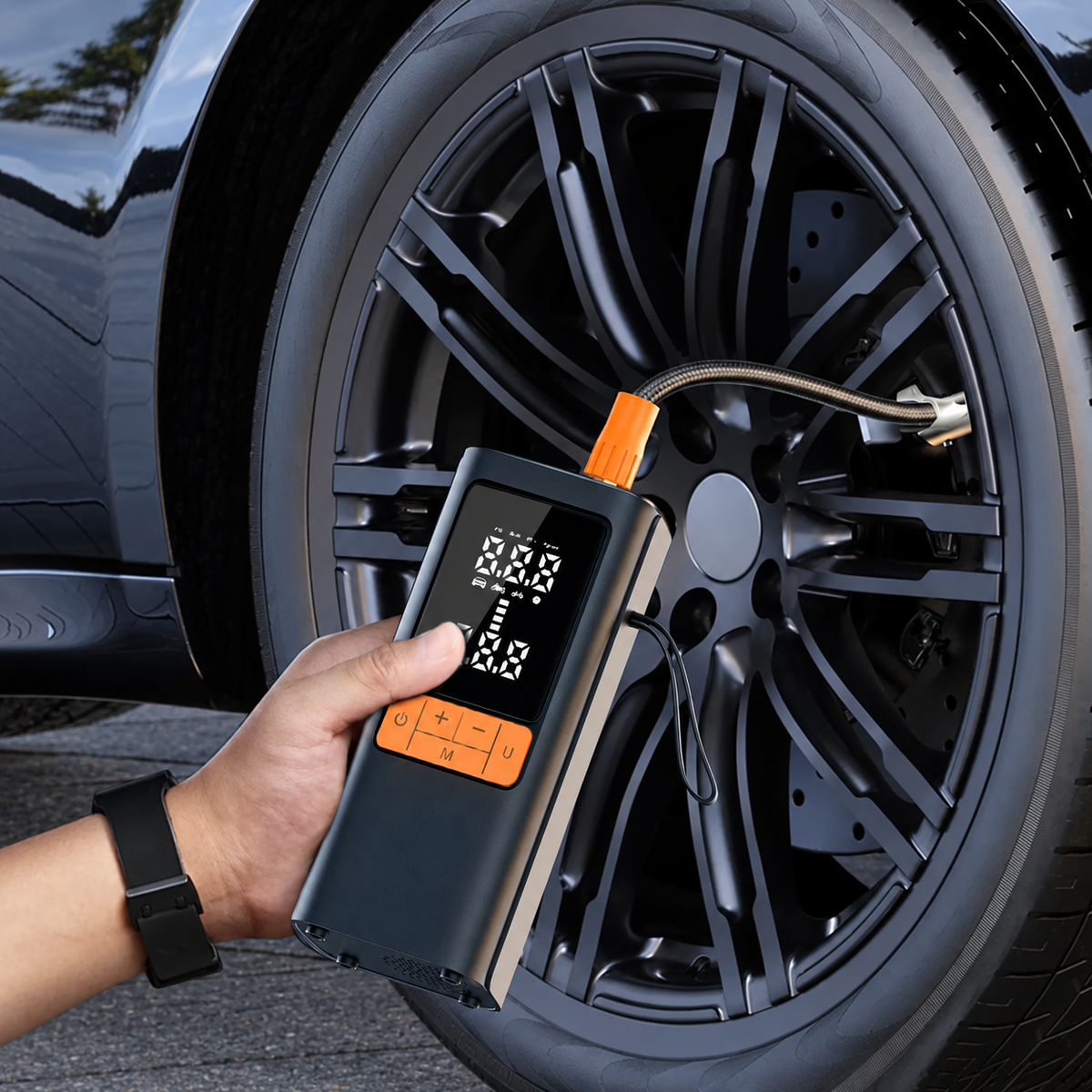 Compresseur portable tenu près d’une roue avec flexible raccordé