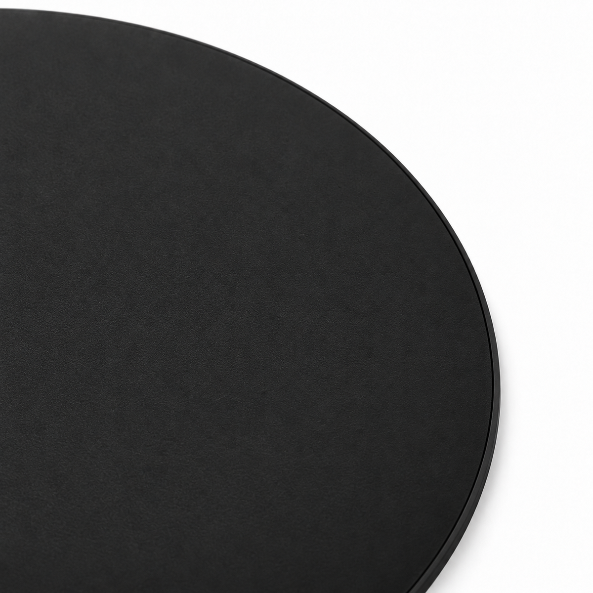 Chargeur sans fil rond noir, détail de la surface mate et du bord